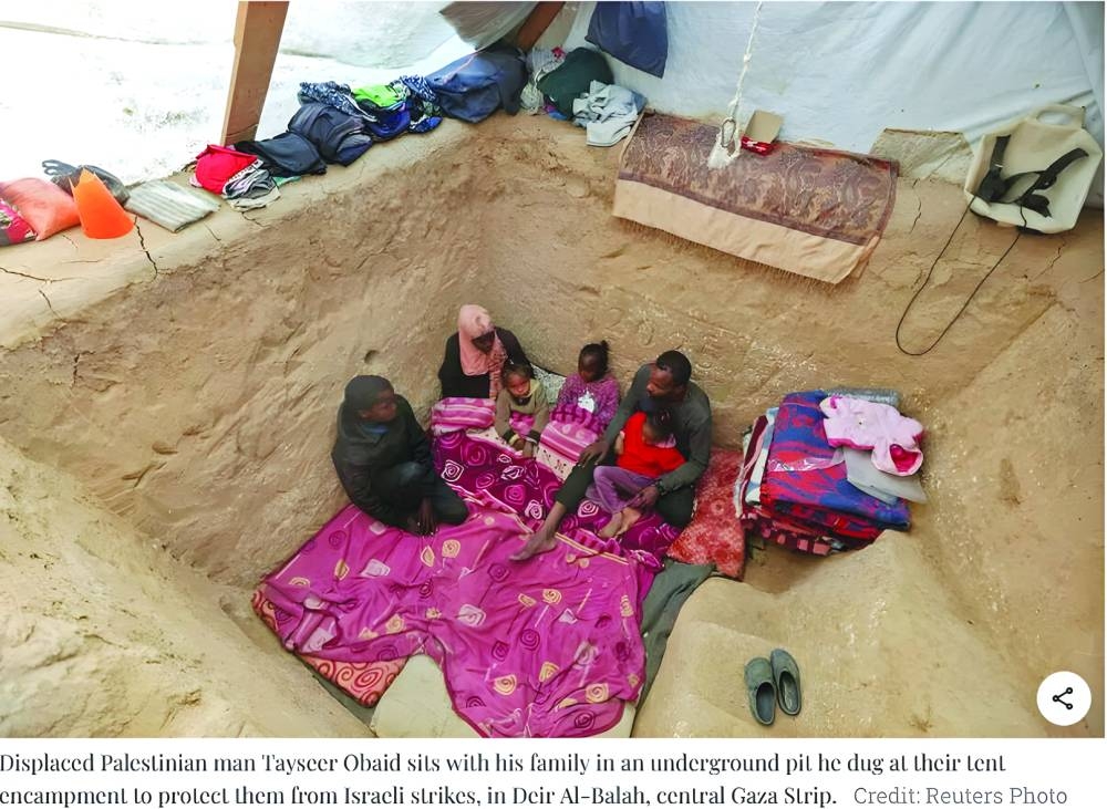 Displaced Gazan digs shelter against winter weather and war