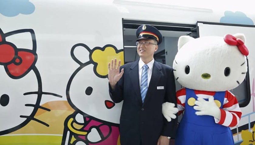 A performer dressed as Hello Kitty poses with a conductor in Taipei on Monday