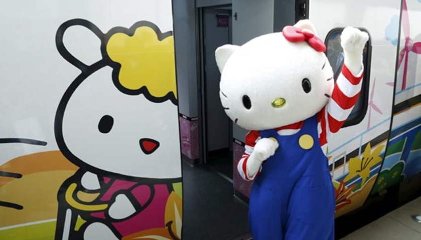 A performer dressed as a Hello Kitty poses next to a Taroko Express train