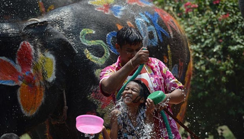 People take part in water fights with elephants as part of the new year celebrations