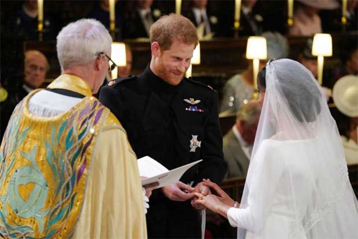 Prince Harry places the wedding ring on the finger of Meghan Markle in Windsor on Saturday