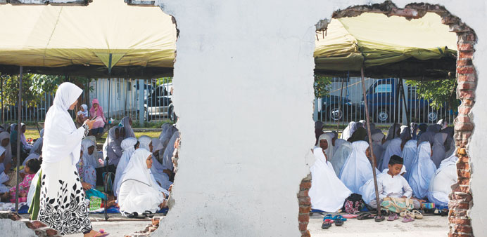 Acehnese people attend a mass prayer to mark the ninth anniversary of Asian tsunami disaster in Banda Aceh yesterday.