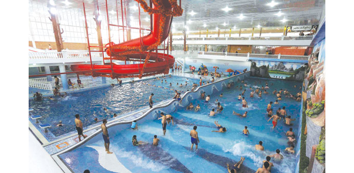 People swim and play around at a public swimming pool in Kabul.