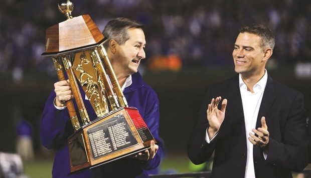 Chicago Cubs owner Tom Ricketts raises the National League Championship Trophy after Game 6 of the 2016 NLCS playoff baseball series, in Chicago on Oct 22. At right is President of Baseball operations Theo Epstein. (Jerry Lai-USA TODAY Sports)