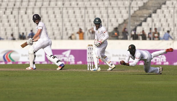 Bangladeshu2019s Shuvagata Hom (right) dives to take a catch to dismiss Englandu2019s Chris Woakes (left) as Bangladeshu2019s captain and wicketkeeper Mushfiqur Rahim looks on during the second Test at Sher-e-Bangla Stadium in Dhaka. (Reuters)