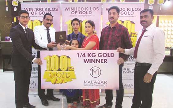 Vijaya G, a raffle draw winner of the u2018Win up to 100 kilos of goldu2019 campaign by Malabar Gold & Diamonds, receiving the prize of 250gm of gold from Joshua Raju, deputy mall manager u2014 Al Khor Mall, in the presence officials from Malabar Gold & Diamonds.