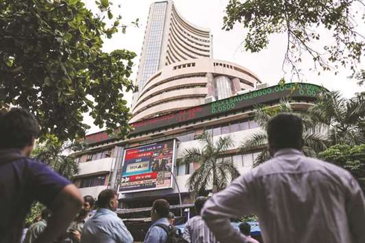 Men look up at an electronic ticker board that indicates stock figures at the Bombay Stock Exchange (BSE) in Mumbai (file). The Sensex has climbed about 31% in dollar terms this year, and is vying with South Koreau2019s benchmark for the top spot among Asiau2019s major markets. Indiau2019s stock market has a total value of about $2.2tn, according to data compiled by Bloomberg.