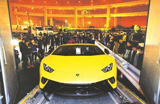 Lamborghini Huracan Performante is rolled off a transport truck as supercar fans look on at Daikoku parking area in Yokohama. Japanese car makers for years have grappled with falling interest in cars among young people, which, along with a rapidly greying society, has led to a 17% fall in domestic vehicle sales since 2000, data from the Japan Auto Dealers Association shows.