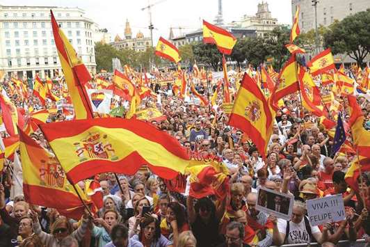 People wave Spanish flags during a demonstration for the unity of Spain in Barcelona.