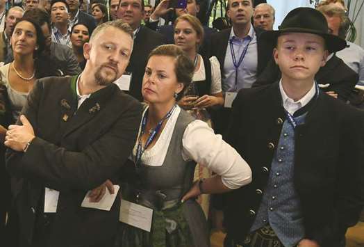 Grim CSU supporters are seen after the first exit polls were announced on public television at the Bavarian regional government building in Munich.