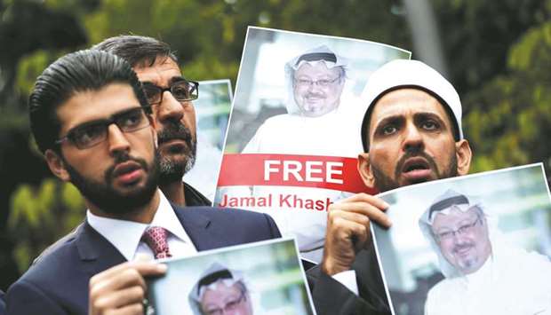 FILE PHOTO: Human rights activists and friends of Saudi journalist Jamal Khashoggi hold his pictures during a protest outside the Saudi Consulate in Istanbul, Turkey, on October 8.