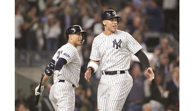 New York Yankees'' Giancarlo Stanton and Aaron Judge head to the outfield  together during game against the Atlanta Braves during a spring training  game at Champion Stadium in Kissimmee, Florida on March