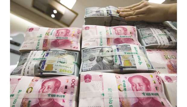 An employee arranges bundles of US dollar and Chinese yuan banknotes at the KEB Hana Bank in Seoul. A US-China currency agreement being floated as a symbol of progress in this weeku2019s trade talks between the worldu2019s two largest economies would largely repeat past pledges by China, currency experts say, and will not change the dollar-yuan relationship that has been a thorn in the side of President Donald Trump.