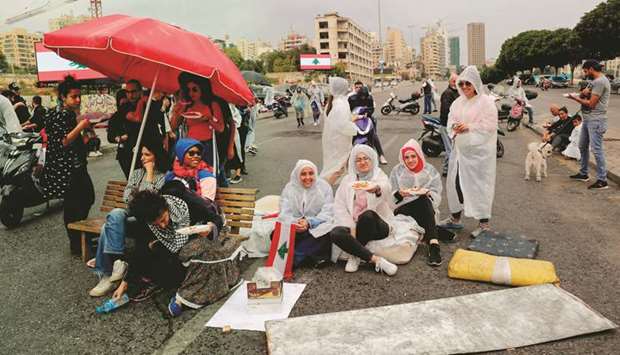 Lebanese protesters have lunch on a blocked avenue in the centre of Beirut yesterday.