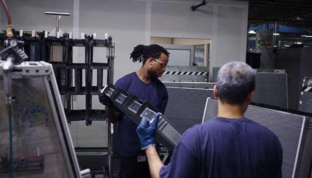 Workers carry a truck engine cooling module component at the MAHLE Behr Charleston auto parts facility in Charleston, South Carolina. Total payrolls at factories contracted by about 2,000 in September, when economists had expected a 3,000 gain.