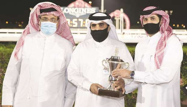 Al Azraq Stable representatives receive the owneru2019s trophy from Qatar Racing and Equestrian Club (QREC) racing manager Mohamed Khalid al-Khalifa (right) yesterday. PICTURES: Juhaim