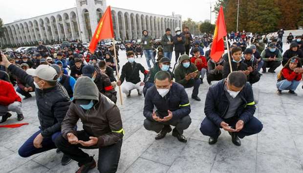 Demonstrators from rival political groups pray during a rally in Bishkek, Kyrgyzstan