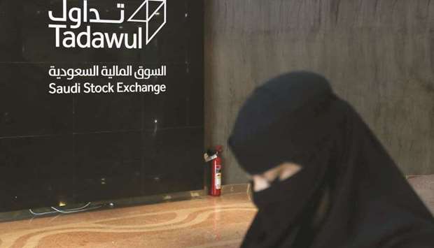 A Saudi woman walks at the stock market Tadawul in Riyadh. A successful listing of Tadawul would represent one of the largest in the exchange sector since Euronext NV, the operator of markets in countries including Belgium, France, the Netherlands and Portugal, went public through a $1.2bn deal in 2014.