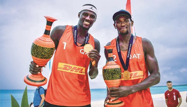 Qataru2019s Cherif Younousse (left) and Ahmed Tijan celebrate with the trophies after winning the Beach Pro Tour Challenge event in Male, Maldives, yesterday.