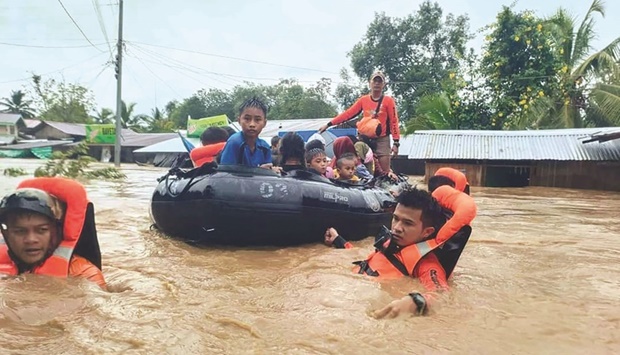 Rescue workers evacuate people from a flooded area due to heavy rain brought by Tropical Storm Nalgae in Parang, Maguindanao province, Philippines.
