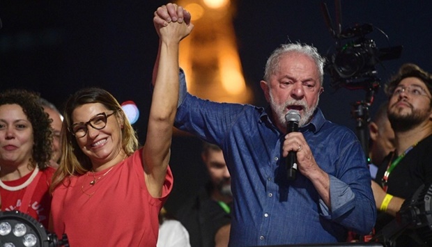 Brazilian president-elect for the leftist Workers Party Luiz Inacio Lula da Silva holds the hand of his wife, Rosangela ,Janja, da Silva, while delivering a speech to supporters at the Paulista avenue after winning the presidential run-off election. (AFP)