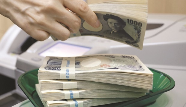 Bundles of Japanese yen banknotes on a tray at a branch of Resona Bank in Tokyo. Japan spent a record $42.4bn in October to counter the yenu2019s sharp slide against the dollar, as it tried to limit speculative moves adding to pressure on the currency.