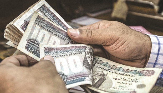 A man counts Egyptian pound banknotes at a currency exchange shop in downtown Cairo (file). Egyptu2019s central bank is set to allow new currency derivatives to unlock liquidity in the local market, making available instruments to hedge against risks to the pound after it fell to a record.