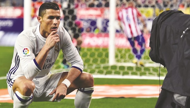 Real Madridu2019s Portuguese forward Cristiano Ronaldo poses in front of a TV camera as he celebrates after scoring during the Spanish league against Atletico de Madrid.