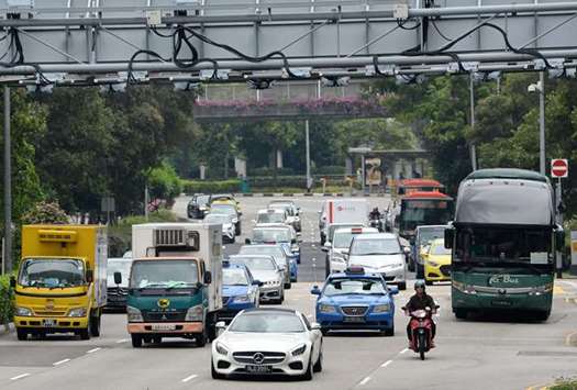 Motorists enter the central business district in Singapore. In the battle against the car, space-starved Singapore has deployed congestion charges, massive spending on public transport, and a licence fee that bumps the cost of an average vehicle to over $80,000.
