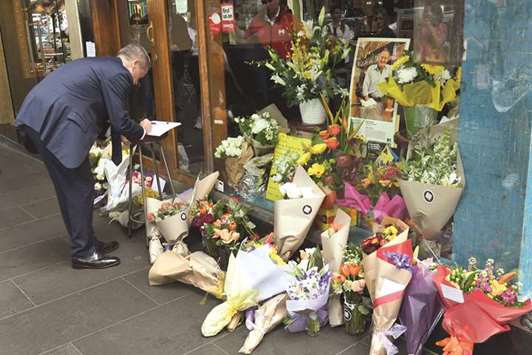 Australiau2019s leader of the opposition Bill Shorten signs a condolence book at a memorial for Sisto Malaspina outside Pellegriniu2019s Espresso Bar in Melbourne yesterday.