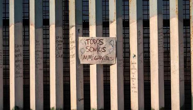 A sign on the US-Mexico border reads in Spanish u201cTodos somos migrantesu201d, (we are all immigrants) in Playas de Tijuana, northwestern Mexico, on November 18.