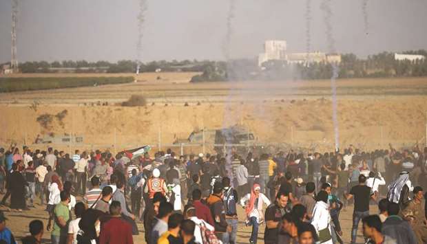 Teargas canisters are fired by Israeli troops towards Palestinians during a protest calling for lifting the Israeli blockade, at the border fence in the southern Gaza Strip, yesterday.