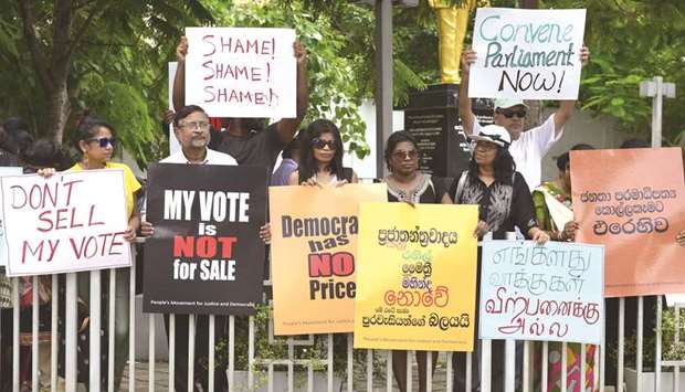Activists hold placards during a demonstration in Colombo yesterday.