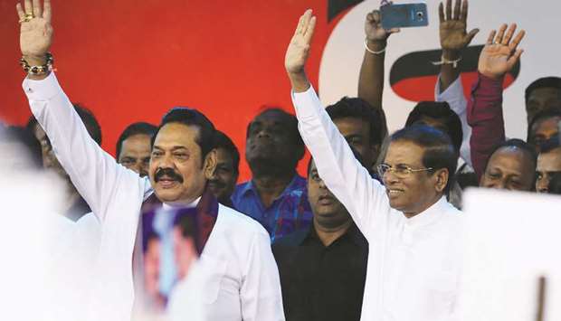 Sri Lankau2019s former president and newly appointed prime minister Mahinda Rajapakse, left, and President Maithripala Sirisena wave to supporters at a rally in Colombo yesterday.