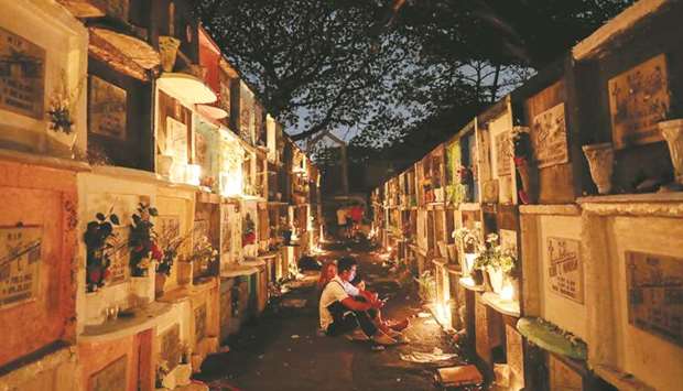 Filipinos light candles on apartment-style graves for their departed loved ones on All Saintsu2019 Day at a public cemetery in Makati City, Metro Manila, yesterday.