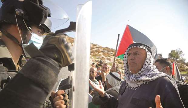 A Palestinian demonstrator argues with a border police member during a protest against Jewish settlements, in Beit Dajan in the occupied West Bank, yesterday.