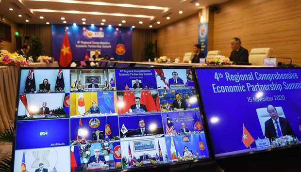 Vietnam's Prime Minister Nguyen Xuan Phuc is pictured on the screen (R) as he addresses his counterparts during the 4th Regional Comprehensive Economic Partnership (RCEP) Summit at the Association of Southeast Asian Nations (ASEAN) summit being held online in Hanoi. AFP