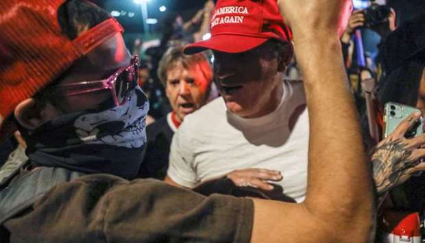 Supporters of US President Donald Trump and counter-protesters yell at each other during a protest about the early results of the 2020 presidential election, in front of the Maricopa County Tabulation and Election Center, in Phoenix, Arizona