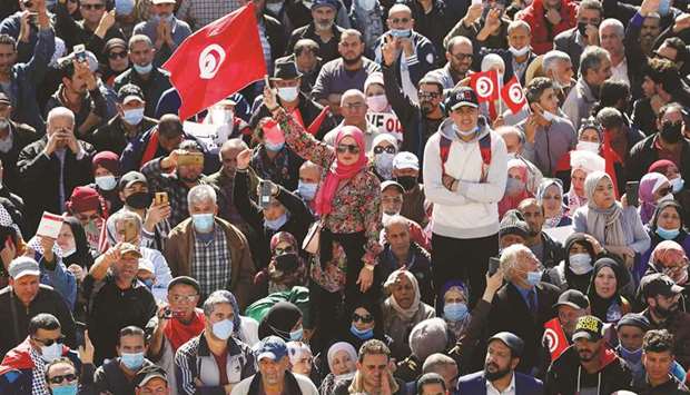 Demonstrators hold flags during a protest against Tunisian President Kais Saiedu2019s seizure of governing powers, in front of the parliament, in Tunis, yesterday.