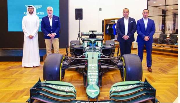 Aston Martin Lagonda executive chairman Lawrence Stroll and ALM team flank Aston Martin F1 Show Car at the British brandu2019s West Bay showroom at Alfardan Towers.