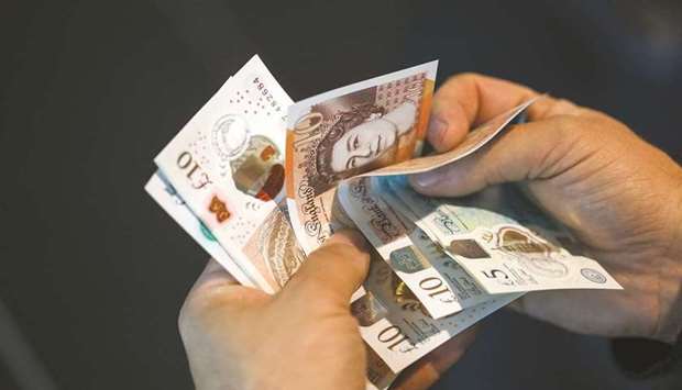 A man holds pound sterling banknotes in an arranged photograph in London. Traders are taking an increasingly negative view on the pound, betting that the decline thatu2019s already left the currency near its lowest this year has further to run.