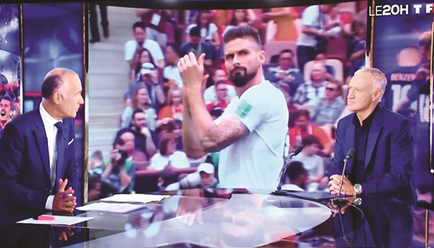 Franceu2019s head coach Didier Deschamps speaks to journalist Gilles Bouleau (left) after announcing squad for the FIFA World Cup  Qatar 2022 during the evening news broadcast of French TV channel TF1 as Olivier Giroud is displayed on the screen. (AFP)