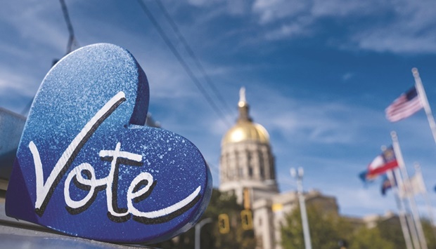 The Georgia State Capitol building is seen behind a u201cVoteu201d sign, a day after the US midterm election, in Atlanta, Georgia yesterday. The US Senate contest in Georgia that could determine which party controls the upper chamber of Congress is headed for a December runoff, media projections show. (AFP)