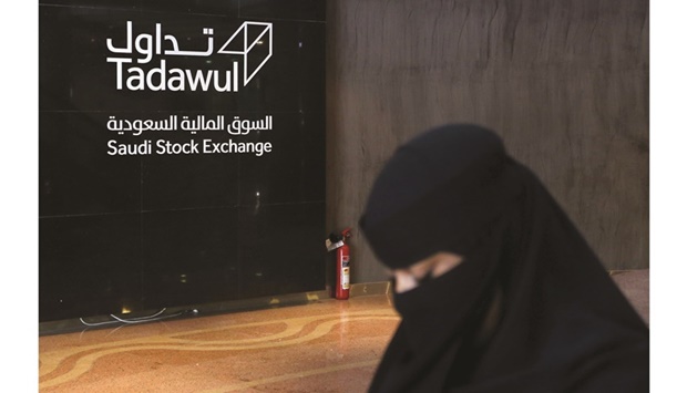A Saudi woman walks at the Saudi stock market (Tadawul) in Riyadh (file). Based on the closing price of 209.60 riyals yesterday, the deal could raise about 2.52bn riyals ($669mn).