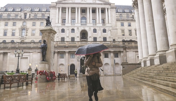 A pedestrian walks past the Bank of England in the City of London. The BoE signalled it will move cautiously in selling off the $22bn of UK government bonds it snapped up in emergency action in recent weeks, outlining a u201cdemand-ledu201d approach to the sales.