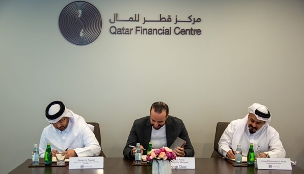 Ghassan Kosta, country manager, Google Cloud; and Yousuf Mohamed al-Jaida, chief executive officer, QFCA, signing the pact. Also seen is Nasser al-Taweel, QFCAu2019s deputy chief executive officer as well as chief legal officer and board secretary.