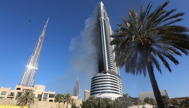 Plumes of smoke rise from the 63-storey Address Downtown Dubai hotel and residential block near the Burj Khalifa, a day after the hotel caught fire.