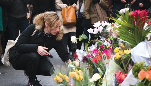 A woman places a floral tribute beneath a mural of singer David Bowie, in Brixton, south London, yesterday.