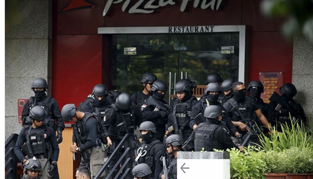 Police gather outside a restaurant near the scene of an attack in central Jakarta. Reuters