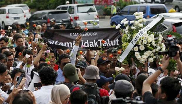 People carry a banner reading ,We grieve. We are not afraid, during a rally at the scene of Thursday